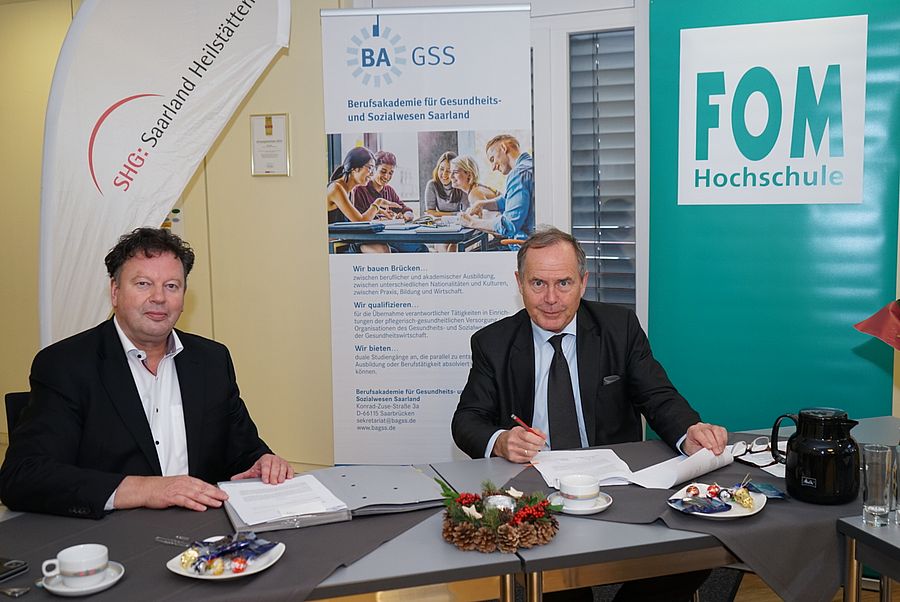 BAGSS-Geschäftsführer Bernd Mege und Kanzler der FOM Hochschule Dr Harald Beschorner unterzeichnen Vertrag