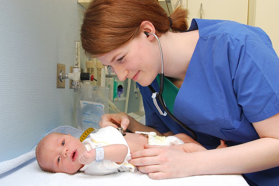 Pflegekraft kümmert sich um ein Neugeborenes