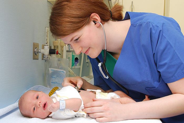 Pflegekraft kümmert sich um ein Neugeborenes