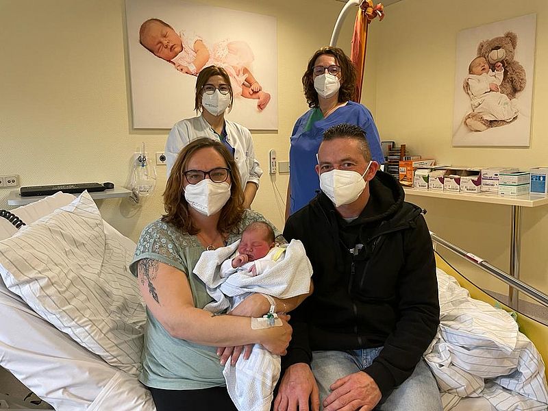 Das frischgeborene Baby mit Eltern, Ärztin und Hebamme