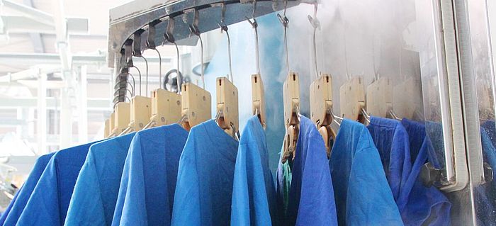 Arbeitskleidungen des Pflegepersonals hängen auf einer Stange