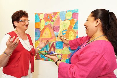 Ergotherapeutin mit einer Patientin bei der Seidenmalerei