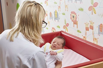 Kinderkrankenschwester versorgt ein Neugeborenes
