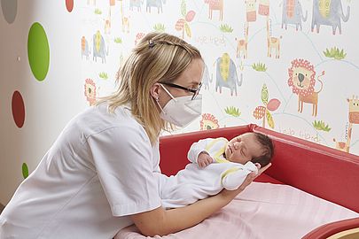 Kinderkrankenschwester versorgt ein Neugeborenes