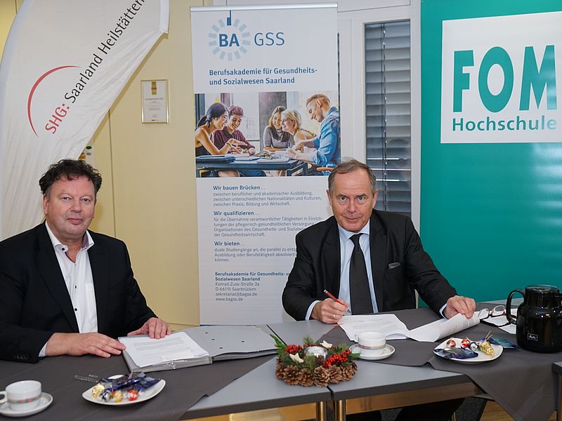 BAGSS-Geschäftsführer Bernd Mege und Kanzler der FOM Hochschule Dr Harald Beschorner unterzeichnen Vertrag