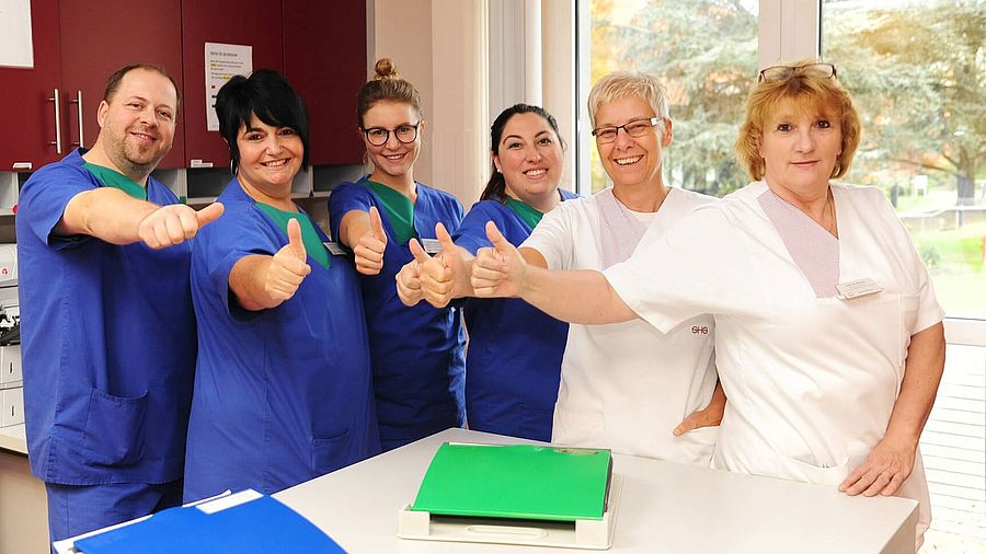 Das Team der Intensivpflege steht nebeneinander und zeigt den Daumen nach oben