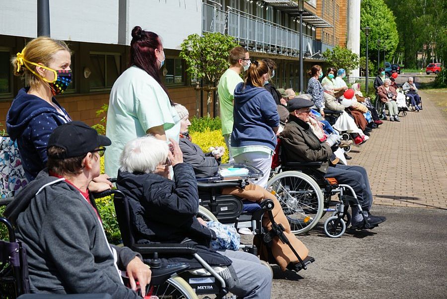 Senioren schauen mit Abstand dem Programm zu