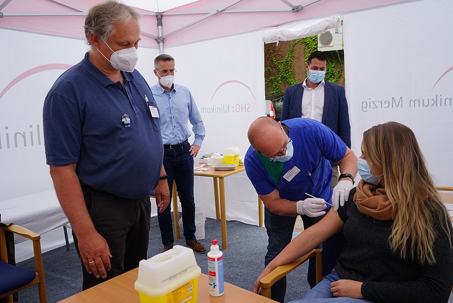 Hans-Peter Schumacher pflegerischer Leiter der Interdisziplinären Intensivstation des Klinikums Merzig, zeigt wie geimpft wird