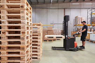 Blick auf einen Mitarbeiter, der im Lager von Apolog einen Gabelstapler bedient