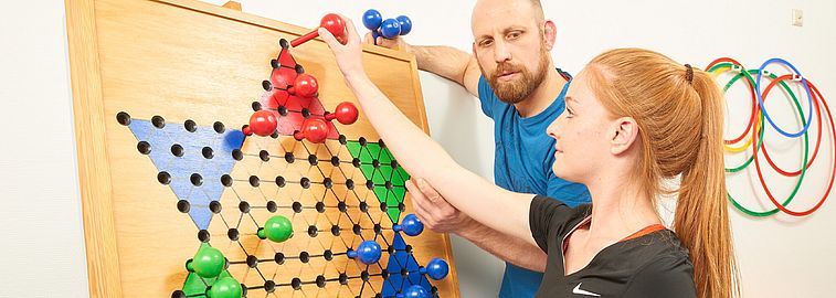 Frau löst Rätsel unter Aufsicht eines Mitarbeiters