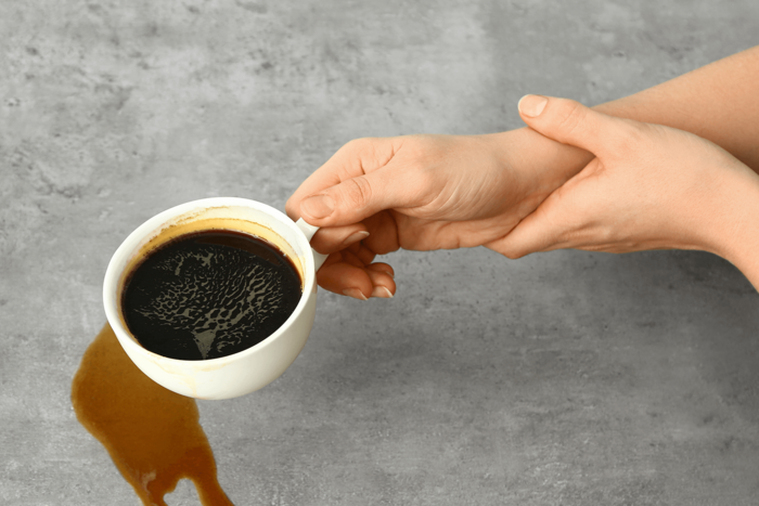 Symbolbild für Klinik für Gerontopsychiatrie, eine Hand hält eine andere Hand, damit diese nicht weiter den Kaffee verschüttet