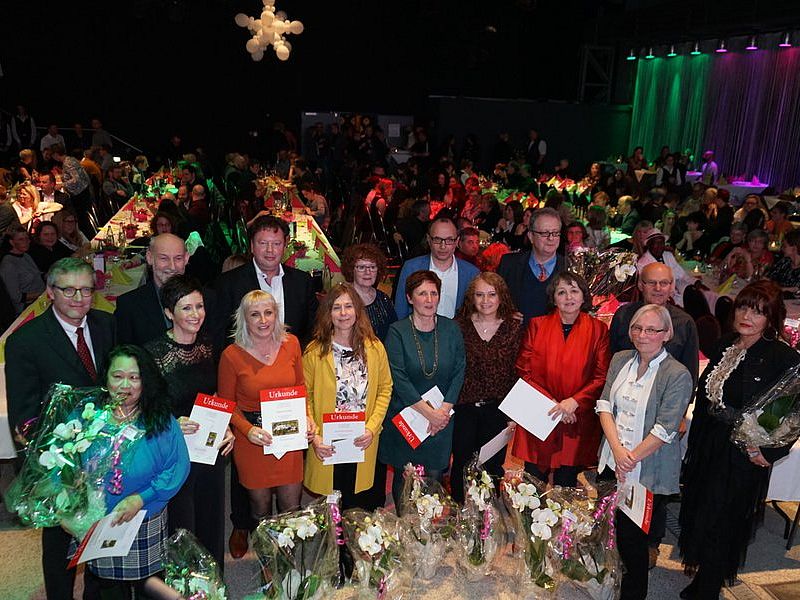 Mitarbeiter erhalten Blumen und Geschenke auf einer großen Veranstaltung