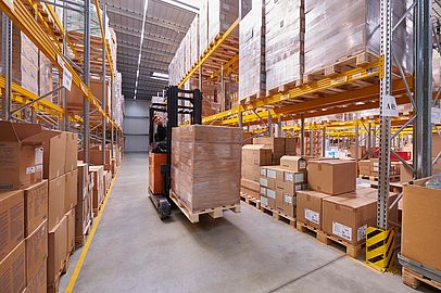 Blick auf einen Mitarbeiter, der im Lager von Apolog einen Gabelstapler bedient